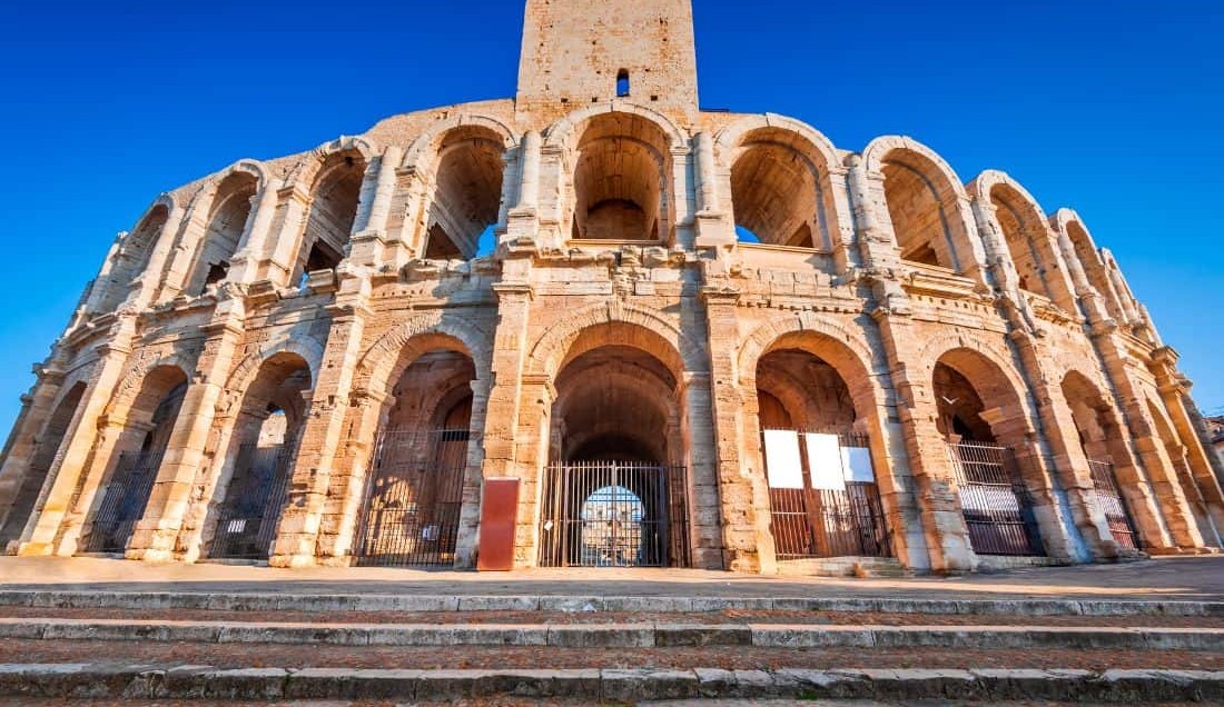 See the ancient roman amphitheatre in Arles