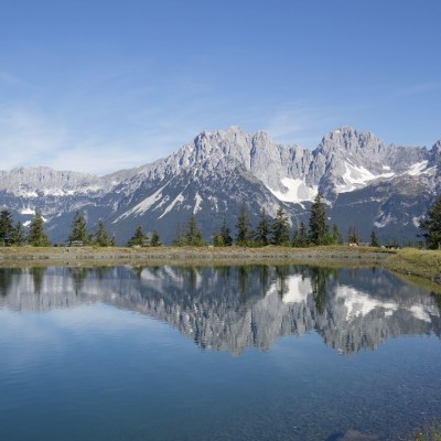 the reflection of the Wilder Kaiser mountain range in Astbergsee lake, located in the Austrian state of Tyro