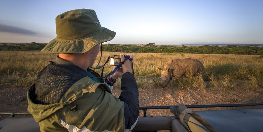 Man on safari taking photo of rhino.jpg
