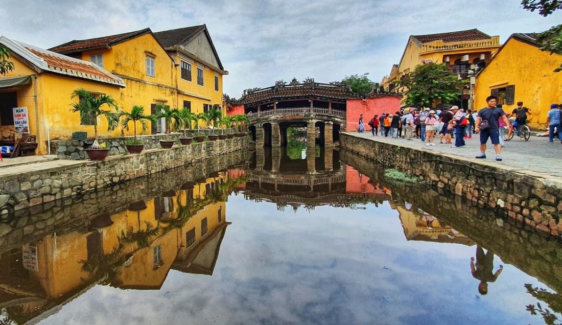 Walk across the Japanese Covered Bridge in Hoi An's Old Town.